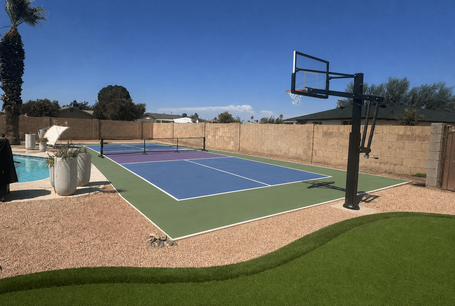 Finished backyard sport court next to a putting green and a pool